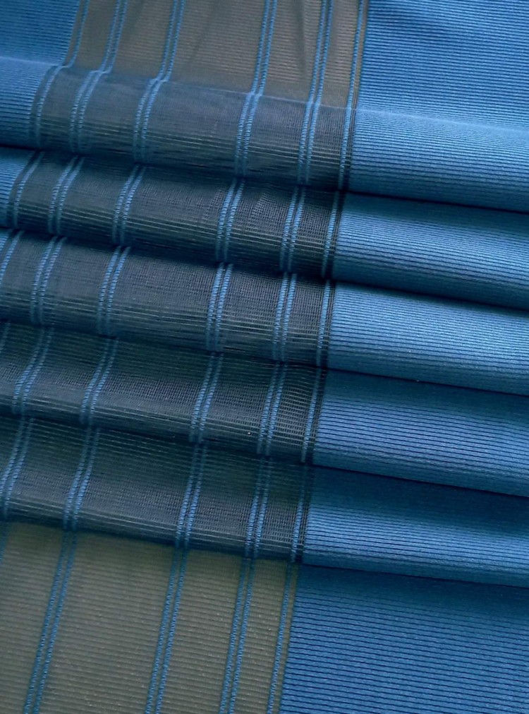«Вальс-Бостон» 33 жалюзийные шторы Жалюзийные шторы серии «Вальс». Коллекция тканей «Вальс-Бостон».  Цвет RAL 5001 «зелёно-синий». Мягкие складки-волны этих красивых штор, выглядят, как единое целое, но на самом деле изготовлены в виде отдельных мягких полос (ламелей). Ламель разделена на три вертикальных части: плотная ткань по краям и прозрачная вуаль между ними. Отделка на прозрачной части выполнена в виде тонких вертикальных линий.